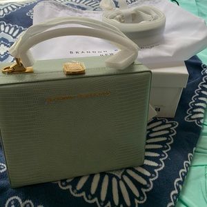 Brandon Blackwood trunk bag in a sage green color with gold hardware.